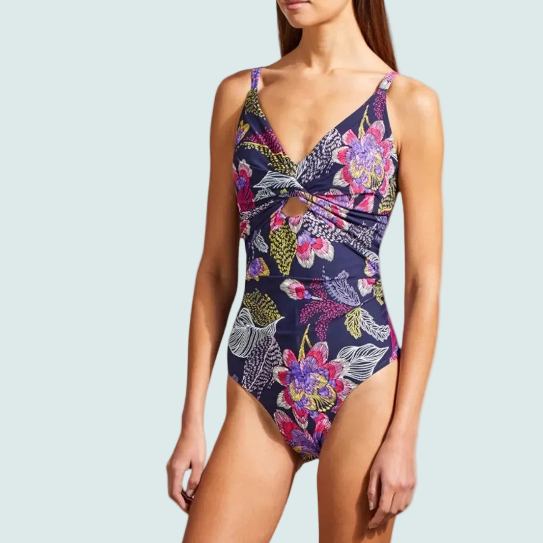 Woman wearing a floral one-piece swimsuit on a white background